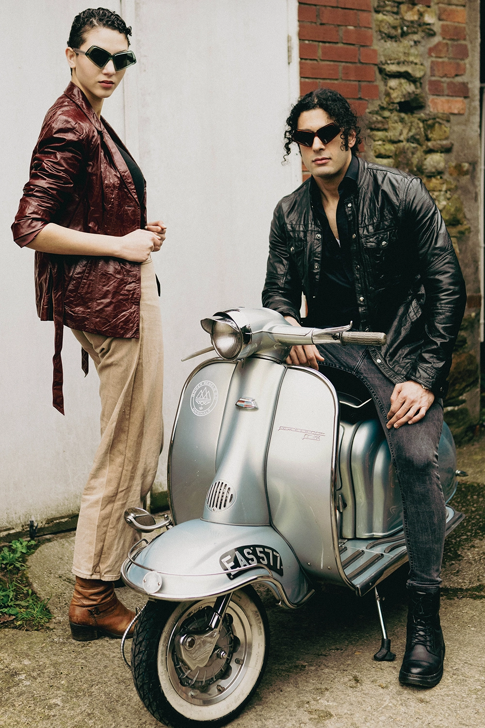 Man and woman in dark Ffin MOD sunglasses with a silver vintage scooter