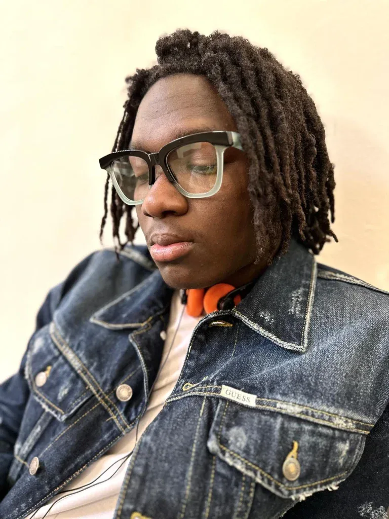 Young man with locs in black Ffin GEN optical frames and a denim jacket