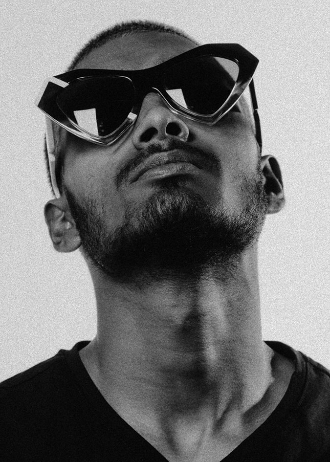 Black and white portrait of a man in angular black Ffin NOS designer sunglasses, chin raised