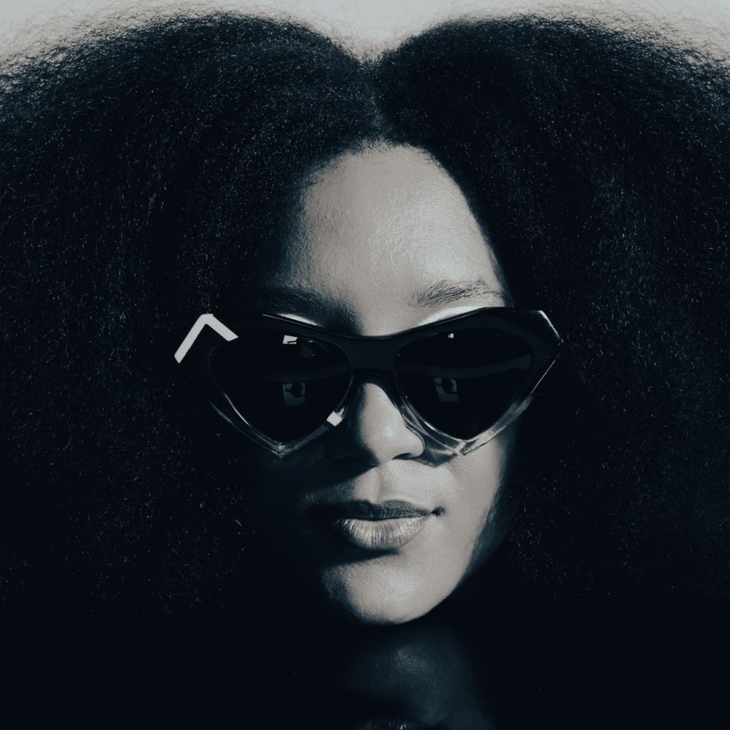 Model with voluminous natural hair in black heart-shaped Ffin NOS designer sunglasses, Love Eyewear Awards shortlist