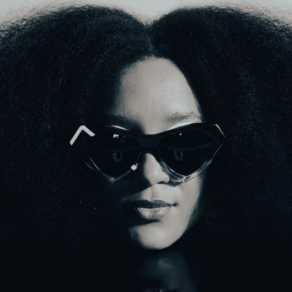Model with voluminous natural hair in black heart-shaped Ffin NOS designer sunglasses, Love Eyewear Awards shortlist