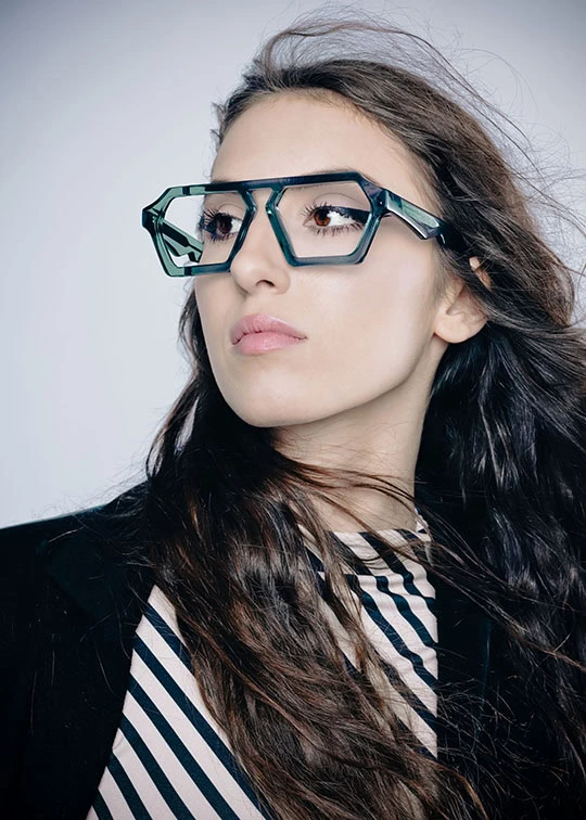 Woman with long dark hair in angular teal Ffin ERA optical frames and a striped top