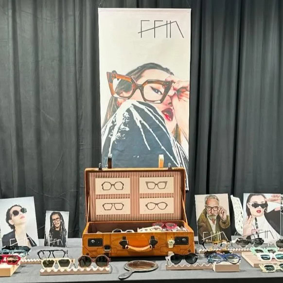 Ffin stand at Bold XXL Optical Fair with a vintage suitcase display, portrait prints and designer eyewear
