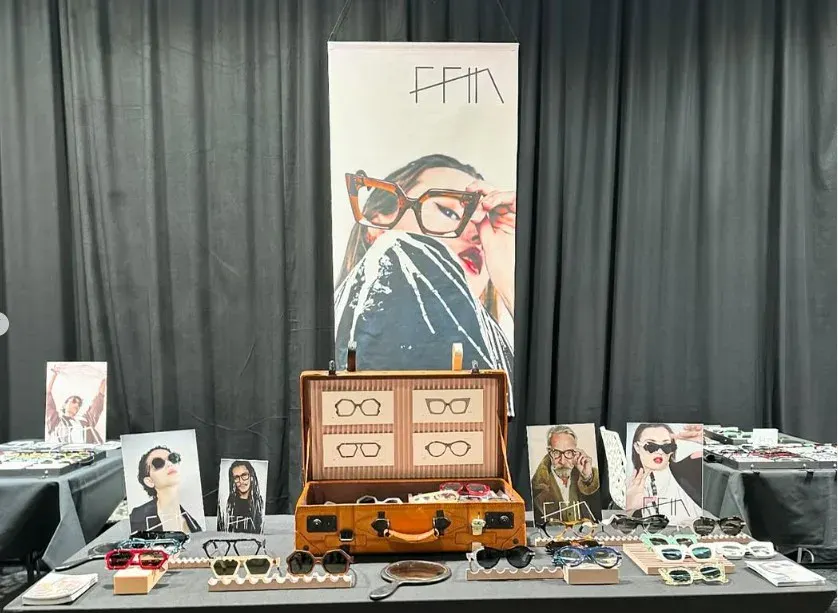 Ffin stand at Bold XXL Optical Fair with a vintage suitcase display, portrait prints and designer eyewear