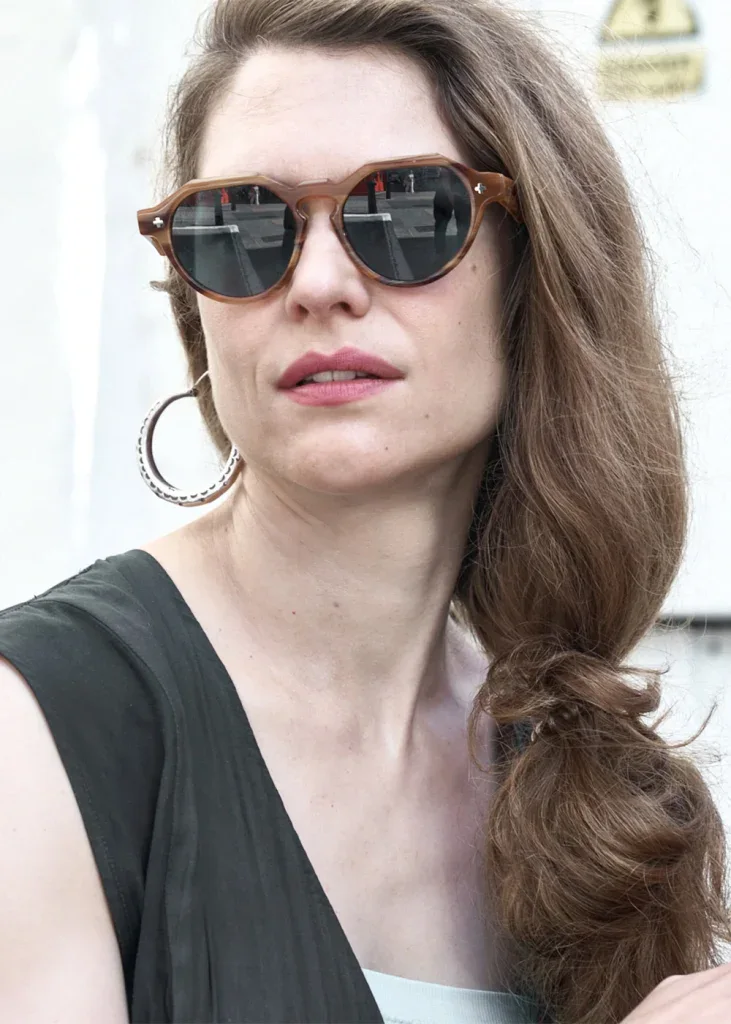 Woman in round tortoiseshell Ffin NON designer sunglasses with large hoop earrings