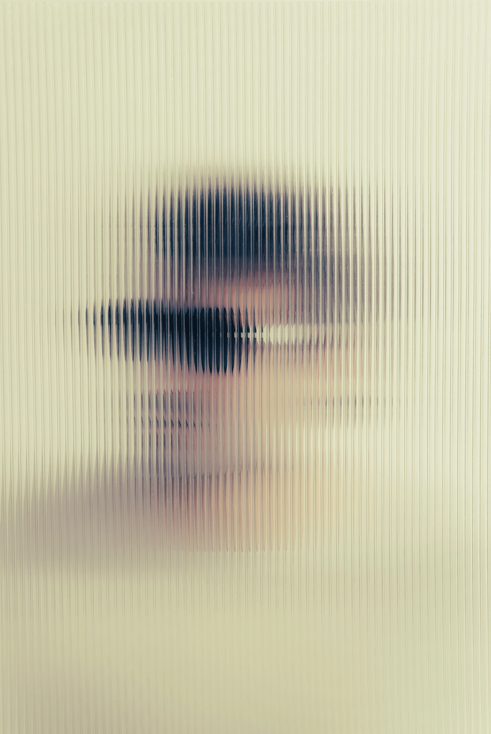 Blurred face behind ribbed glass in Ffin ANA designer sunglasses