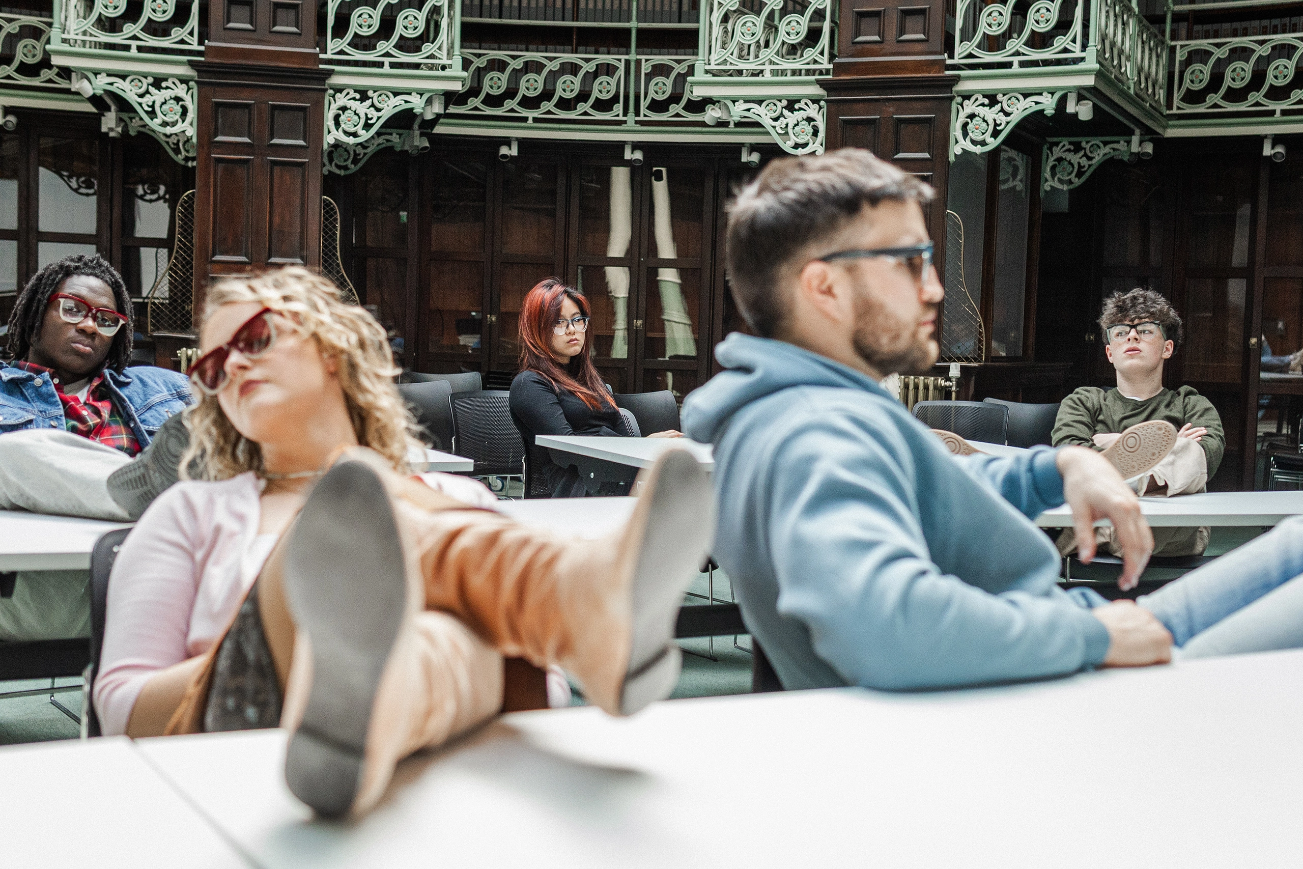 Models lounging at library tables in Ffin GEN sunglasses, Breakfast Club shoot