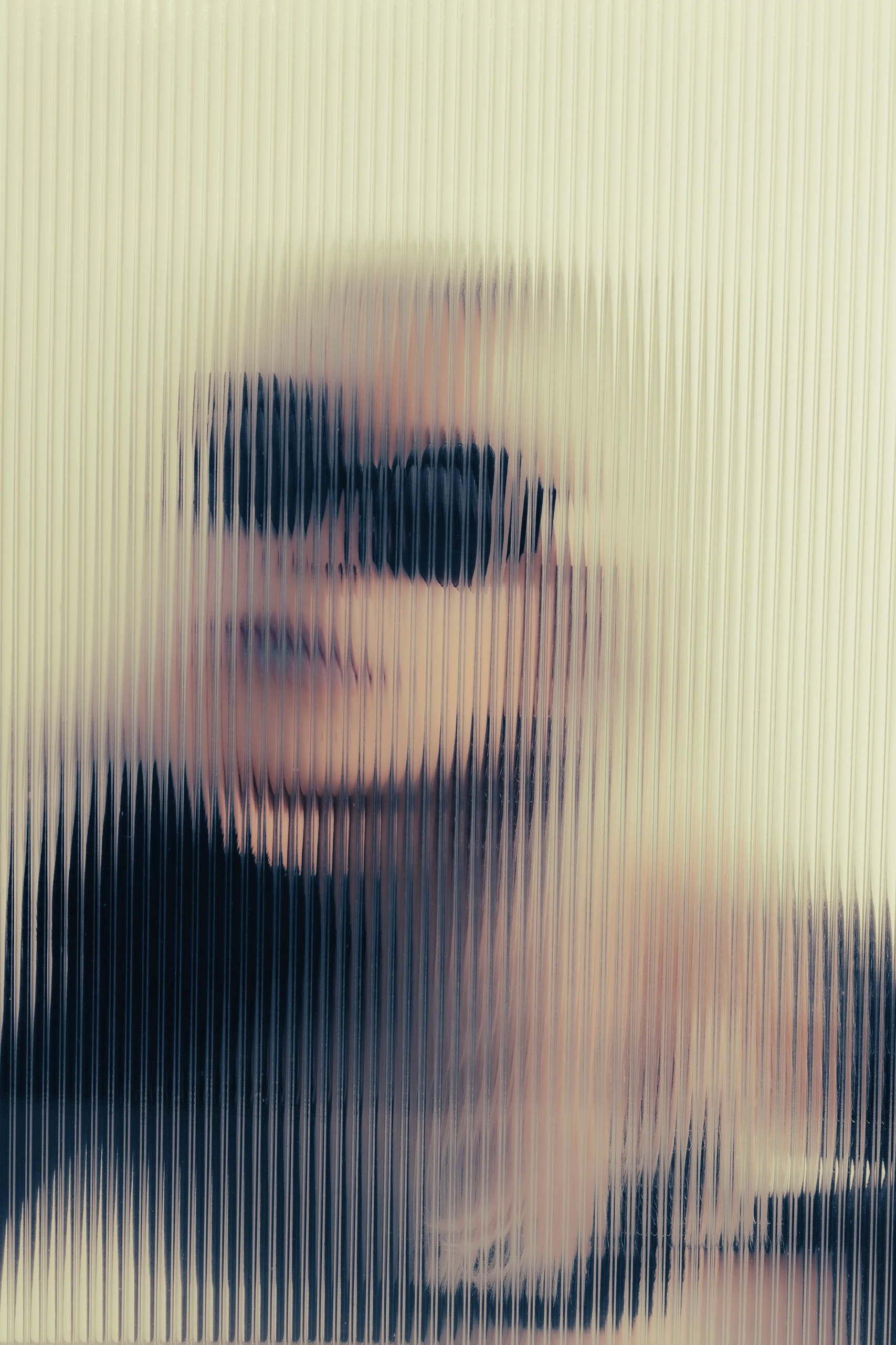 Blurred face behind ribbed glass in Ffin ORA designer sunglasses