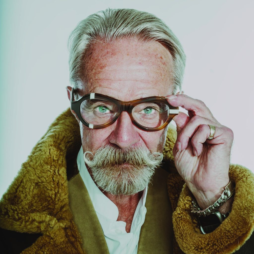 Gary in tortoiseshell Ffin ANA award-winning optical frames and a shearling collar, adjusting the frames