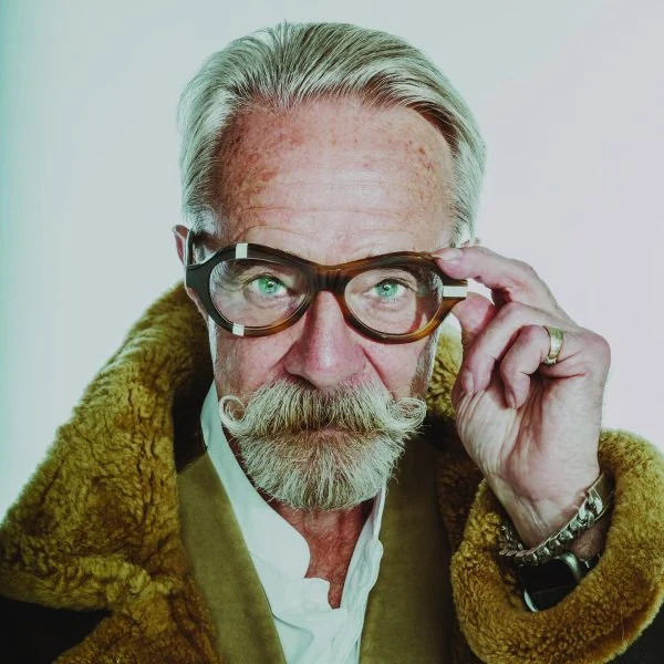 Gary in tortoiseshell Ffin ANA award-winning optical frames and a shearling collar, adjusting the frames