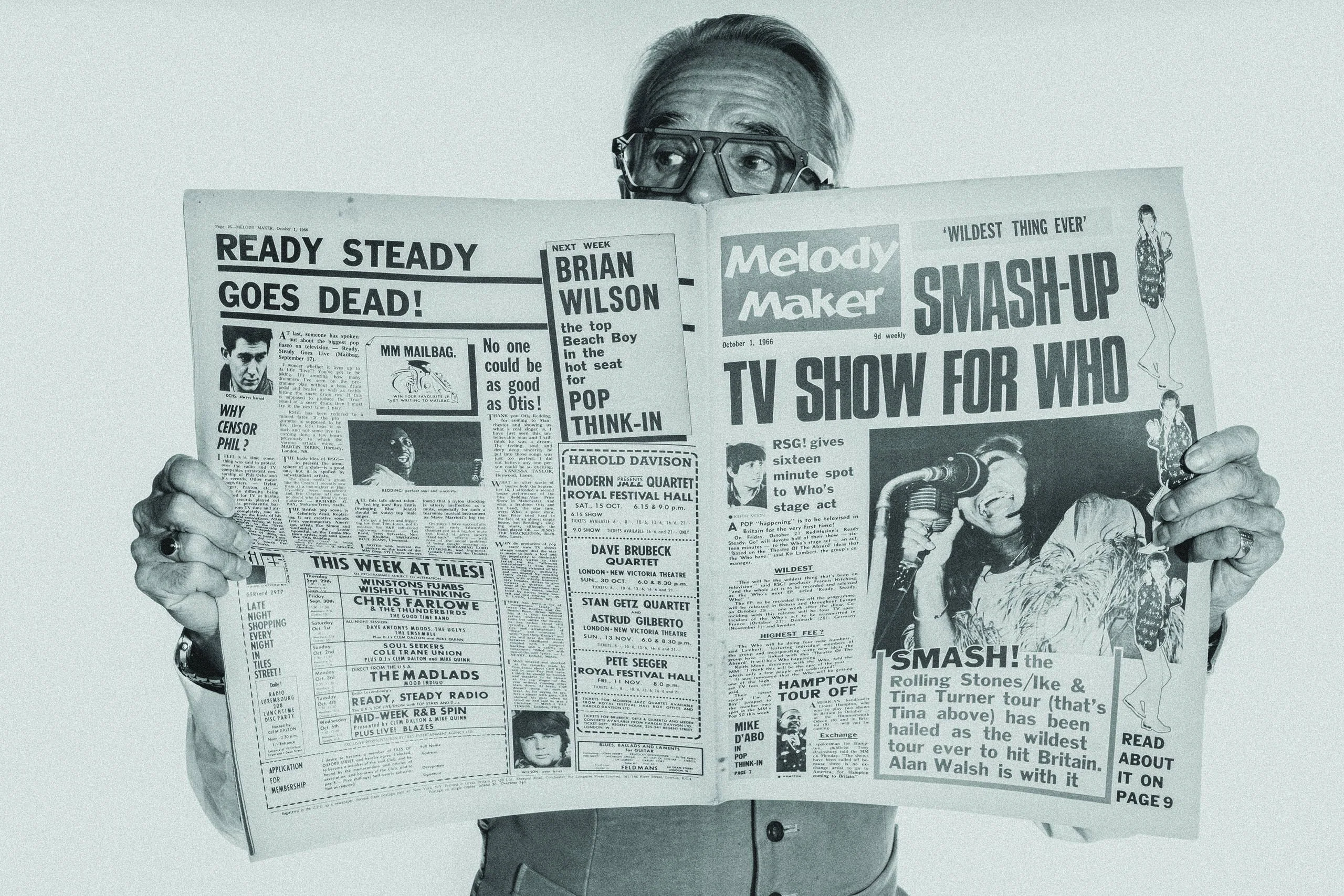 Black and white shot of Gary in Ffin ERA optical frames behind a vintage Melody Maker newspaper