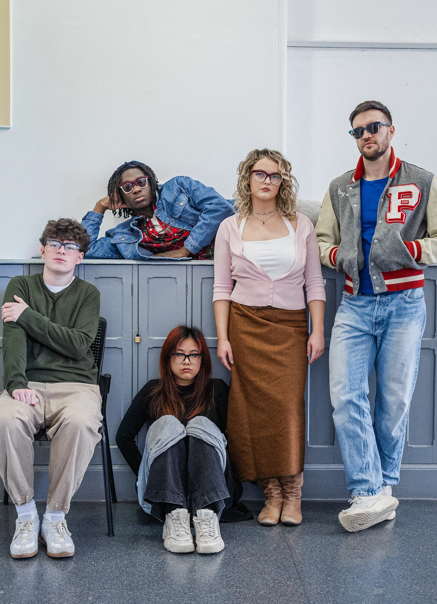 Five models in Ffin GEN eyewear standing and sitting before school lockers, a Breakfast Club homage