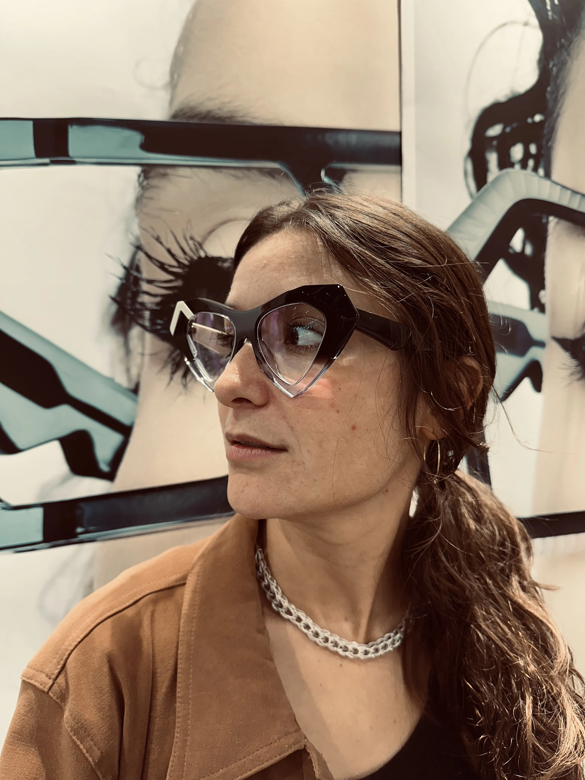 Woman in black and clear heart-shaped Ffin NOS designer sunglasses at the Ffin stand at SILMO