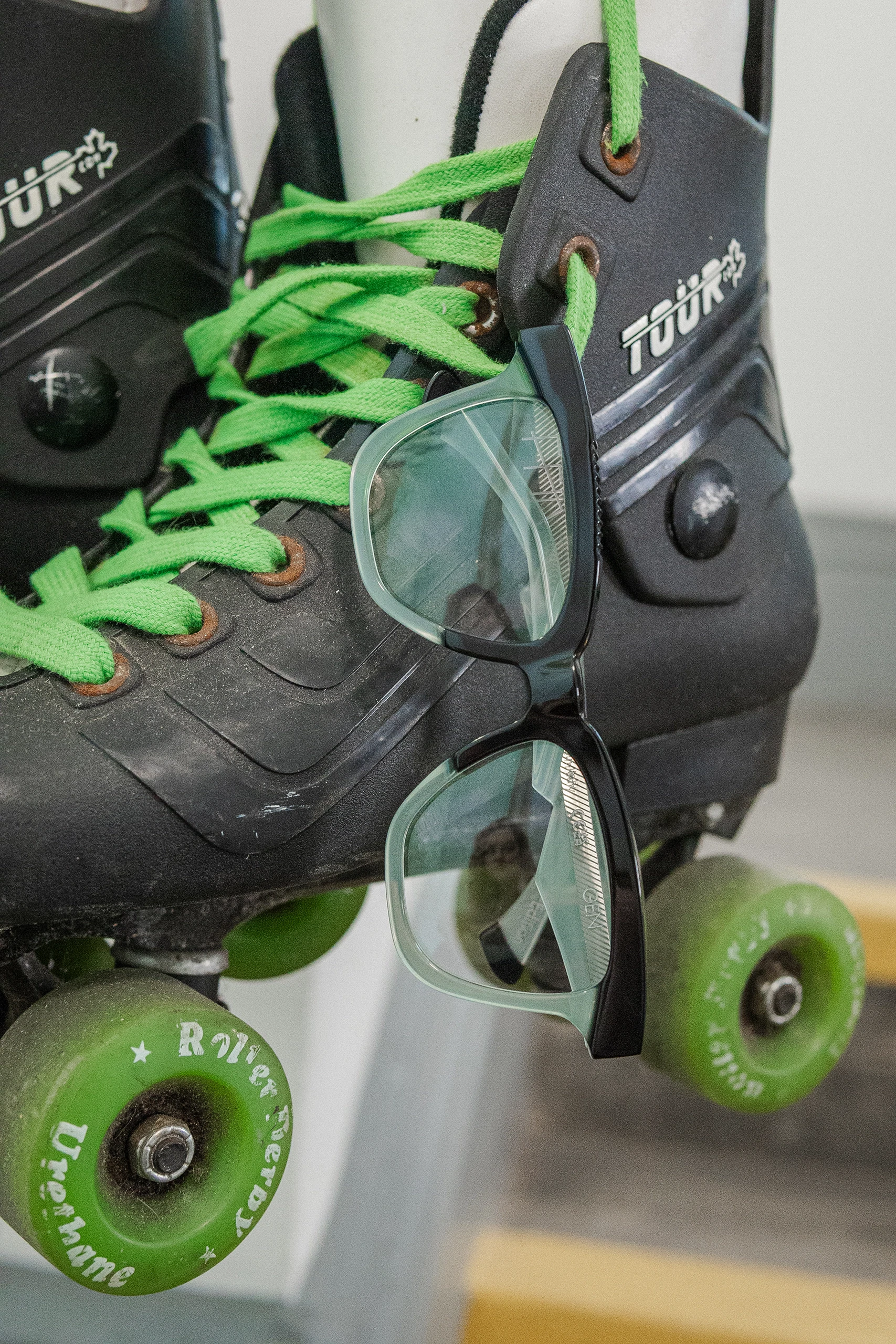 Black Ffin GEN optical frames hung over the laces of a pair of roller skates