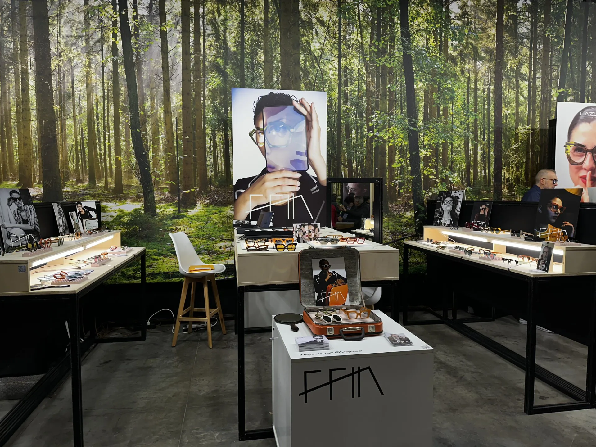 Full view of the Ffin stand at MIDO with a woodland backdrop and portrait prints