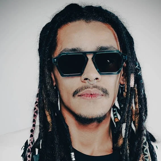Man with locs in dark teal Ffin ERA designer sunglasses, face-on portrait